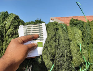 A snapshot of a yarn pile matching a pantone color reference in a bold green.